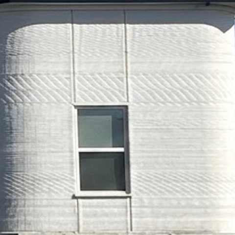 Close-up of a curved printed concrete wall showing its layered texture